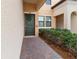 Front entrance with a dark-green door and brick pathway at 10031 Crooked Creek Dr # 201, Venice, FL 34293