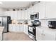 Modern white kitchen with stainless steel appliances and white cabinetry at 10031 Crooked Creek Dr # 201, Venice, FL 34293