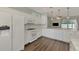 Open concept kitchen with white cabinets and island, looking into living room at 11508 Water Willow Ave, Lakewood Ranch, FL 34202