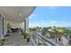 Spacious balcony with ocean view, seating area, and lush tropical plants at 1300 Benjamin Franklin Dr # 504, Sarasota, FL 34236