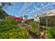 Private backyard with brick patio, lush landscaping and red umbrella at 131 Pinehurst Dr # 131, Bradenton, FL 34210