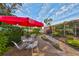 Patio seating area with red umbrella and surrounding garden at 131 Pinehurst Dr # 131, Bradenton, FL 34210