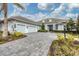 Two-story home with light blue exterior, gray paver driveway and landscaping at 16007 Castle Park Ter, Lakewood Ranch, FL 34202