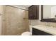 Bathroom boasts a shower, vanity with a quartz countertop, and dark wood cabinet at 1608 Stickney Point Rd # 1608-102, Sarasota, FL 34231