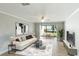 Bright living room with water view, featuring tiled floors and sliding glass doors at 1608 Stickney Point Rd # 1608-102, Sarasota, FL 34231