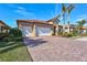 House exterior with a two-car garage and nicely landscaped front yard at 215 Toscavilla Blvd, Nokomis, FL 34275