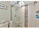 Walk-in shower with pebble tile detail and glass enclosure at 2154 Lakewood Dr, Nokomis, FL 34275