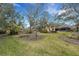 Lush backyard featuring a green lawn, mature trees, and well-maintained landscaping at 2218 Shadow Oaks Rd, Sarasota, FL 34240