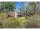 Landscaped backyard with a screen-enclosed lanai providing a relaxing outdoor living space at 2218 Shadow Oaks Rd, Sarasota, FL 34240