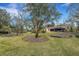 Large backyard with a well-kept lawn, mature trees, and space for outdoor activities at 2218 Shadow Oaks Rd, Sarasota, FL 34240