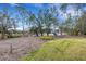 Tranquil backyard with mature trees, a grassy lawn, and a glimpse of the lake at 2218 Shadow Oaks Rd, Sarasota, FL 34240
