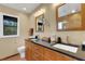 Bright bathroom featuring double sinks, dark granite countertop, and stylish fixtures at 2218 Shadow Oaks Rd, Sarasota, FL 34240