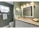 Charming bathroom with beadboard cabinet, updated fixtures, and window at 2218 Shadow Oaks Rd, Sarasota, FL 34240