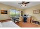 Bedroom with a large window with window treatments, ceiling fan and wood floors at 2218 Shadow Oaks Rd, Sarasota, FL 34240