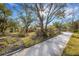 Long driveway leading to a house surrounded by mature trees enhancing its privacy at 2218 Shadow Oaks Rd, Sarasota, FL 34240