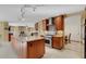 Open kitchen showcasing stainless steel appliances, an island, and a view of the living area with a stone fireplace at 2218 Shadow Oaks Rd, Sarasota, FL 34240