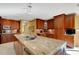 Spacious kitchen featuring custom cabinets, granite countertops, a central island, and stainless steel appliances at 2218 Shadow Oaks Rd, Sarasota, FL 34240