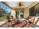 Covered patio with comfortable seating, ceiling fan, and views of lush yard at 2218 Shadow Oaks Rd, Sarasota, FL 34240