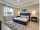 Main bedroom with a navy blue upholstered bed and ensuite bath at 2692 Mctague St, North Port, FL 34291