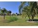 Golf course view with palm trees and buildings in the distance at 2906 Captains Ct, Palmetto, FL 34221