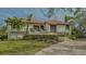 House exterior featuring a tile roof, landscaping, and paver driveway at 3318 Bayou Sound, Longboat Key, FL 34228