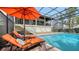 Relaxing poolside oasis featuring orange lounge chairs and umbrella at 3318 Bayou Sound, Longboat Key, FL 34228