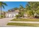 House exterior features a two-car garage, lush landscaping, and a welcoming entryway at 408 Golden Harbour Trl, Bradenton, FL 34212