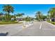 A community entrance with a gate, lush tropical landscaping, and a well-maintained road at 4802 51St W St # 1118, Bradenton, FL 34210