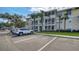 Exterior view of a three-story condo building with beige siding, white trim, and screened-in porches and on-site parking at 4802 51St W St # 1118, Bradenton, FL 34210