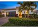 Modern house exterior with a dark garage door and manicured landscaping at 4947 Surfside Cir, Bradenton, FL 34211