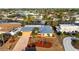 Aerial view of waterfront home featuring a blue metal roof, mature palms, and boat dock at 5207 Bimini Dr, Bradenton, FL 34210