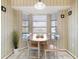 Dining room featuring a light wood table set, tile floors, and natural light from the bay windows at 5207 Bimini Dr, Bradenton, FL 34210