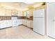 Galley kitchen with white appliances and light beige tile floors at 5400 34Th W St # D12, Bradenton, FL 34210