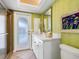 Clean bathroom with green bamboo wallpaper, white vanity, and walk-in shower at 5560 Shadow Lawn Dr, Sarasota, FL 34242