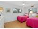 Twin bedroom with pink bedding and bamboo flooring, featuring plantation shutters at 5560 Shadow Lawn Dr, Sarasota, FL 34242