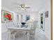 White dining set with glass-top table seats six, located near sliding glass doors at 5560 Shadow Lawn Dr, Sarasota, FL 34242