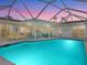 Inviting screened pool area with turquoise water, patio furniture, and a beautiful sunset at 5560 Shadow Lawn Dr, Sarasota, FL 34242