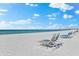 Beach with lounge chairs and calm ocean at 6312 Midnight Pass Rd # 702S, Sarasota, FL 34242