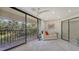 Bright sunroom with sliding glass doors leading to a balcony overlooking a tranquil pond at 6450 Wild Oak Bay Blvd # 238, Bradenton, FL 34210