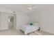 Bright bedroom with neutral carpet features a ceiling fan, bathroom access, and a comfortable bed at 6750 Fairway Gardens Dr # 6750, Bradenton, FL 34203