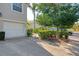 Home exterior featuring an attached garage, lush landscaping, and mature trees at 6750 Fairway Gardens Dr # 6750, Bradenton, FL 34203