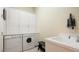 Laundry room with washer, dryer, cabinets, and utility sink at 7244 Orchid Island Pl, Bradenton, FL 34202