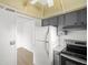 White appliances and gray cabinets in galley-style kitchen at 7304 W Country Club N Dr # 213, Sarasota, FL 34243