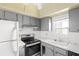Gray kitchen cabinets, stainless steel appliances, and a window at 7304 W Country Club N Dr # 213, Sarasota, FL 34243