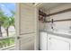 In-unit laundry with washer and dryer and storage shelves at 7304 W Country Club N Dr # 213, Sarasota, FL 34243