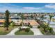 Aerial view of a waterfront home with circular driveway, lush landscaping, and boat access at 740 Old Compass Rd, Longboat Key, FL 34228