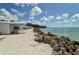 White cabanas and sandy beach area next to the ocean at 7429 Sanderling Rd, Sarasota, FL 34242