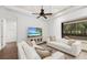 Living room with white sofas, a large TV, and sliding doors to a patio at 7728 Rio Bella Pl, Bradenton, FL 34201