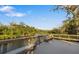 Scenic boardwalk with benches overlooking a calm river, lush greenery at 7728 Rio Bella Pl, Bradenton, FL 34201
