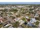An aerial view shows a home with a well-kept lawn, mature trees, and a sunroom in a residential area at 807 62Nd W St, Bradenton, FL 34209